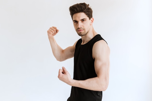 handsome young strong sports man posing and showing biceps.