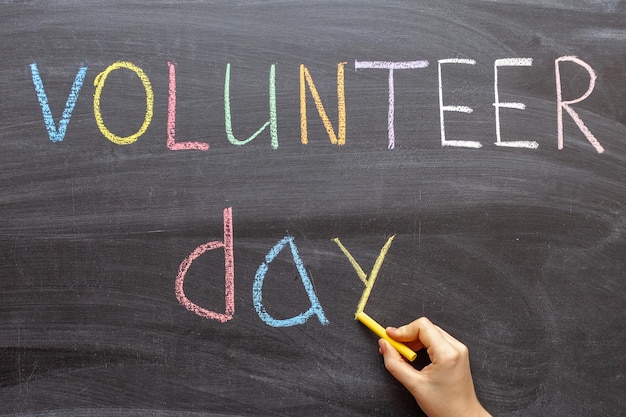 Handwritten text on a chalkboard "volunteer day".