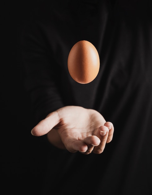 Handy baker throwing egg in air