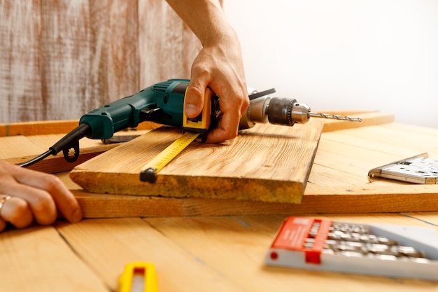 Handyman in blue uniform works with electricity automatic screwdriver. House renovation conception.