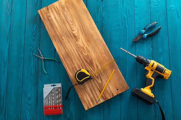 Handyman in blue uniform works with electricity automatic screwdriver