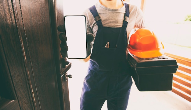 The handyman showing the phone with blank white screen in the home entrance