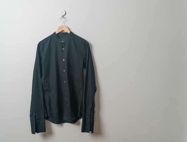 hanging black shirt with wood hanger on wall