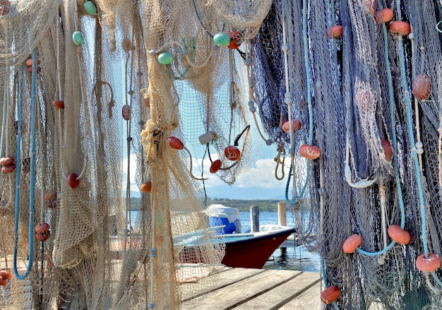 Hanging fishing nets stowed on a pontoon in front of a boat