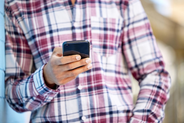 Hanging out during his free period Closeup shot of an unrecognisable student using a cellphone on campus