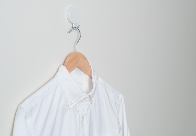 Hanging shirt with wood hanger on wall