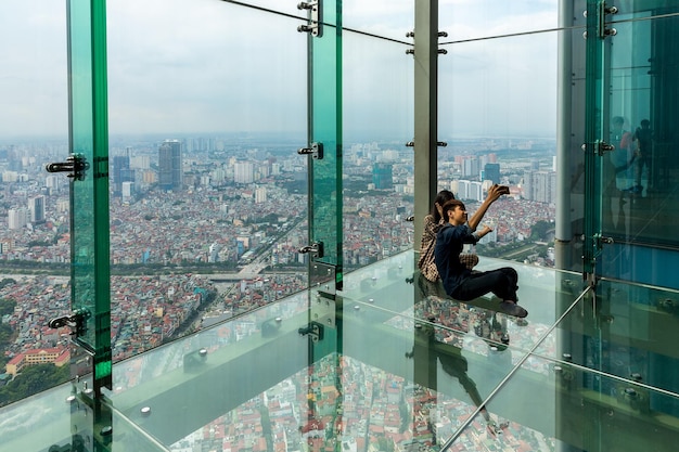 Hanoi, Vietnam - 09.08. 2019 - Tourists take selfies on the Lotte Center glass observation deck.