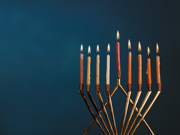 Hanukkah menorah with candles for chanukah celebrationon black background