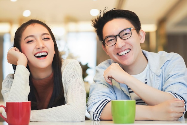 Happiness asian couple laugh smile together with in kitchen pantry humor emotional casual relax with room interior background