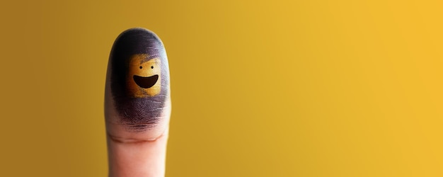 Happiness Day Concept Happy and Positive Mind Well Mental Health Enjoying Life Everyday Smiling Face on Thumb against Yellow Wall