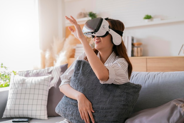 Happiness exited asian female teen hand wave along with her virtual concert performance via virtual goggle virtual interactive headsetasia woman stay home innovation technology lifestyle vr at home