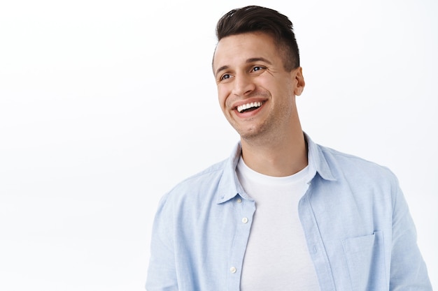 Happiness, family and emotions concept. Close-up portrait of handsome happy young man with stylish haircut, look away left empty space with pleased cheerful smile, laughing and rejoicing