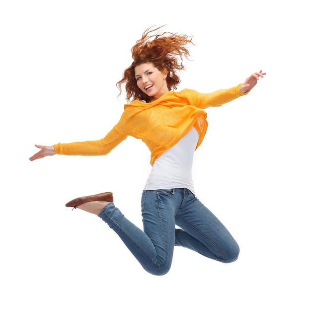 Photo happiness, freedom, movement and people concept - smiling young woman jumping in air