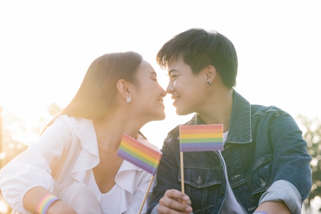 Happiness LGBT lesbian couple holding rainbow flag in hand.