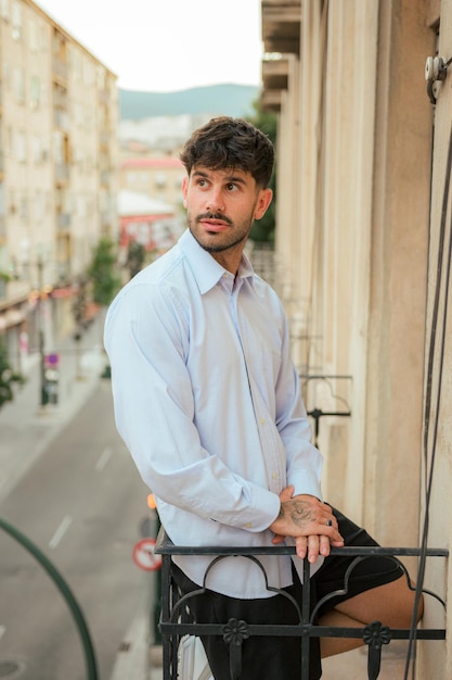 Happiness man smiles and poses in a balcony