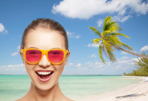 happiness and people concept - portrait of happy teenage girl in pink sunglasses