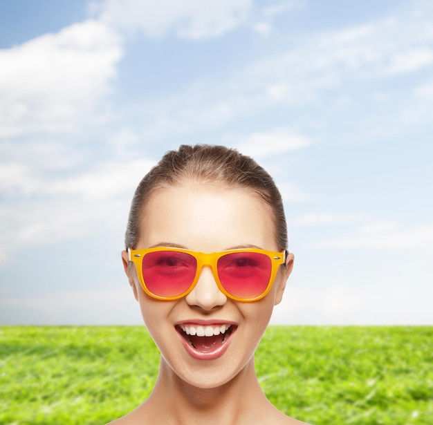 happiness and people concept - portrait of happy teenage girl in pink sunglasses