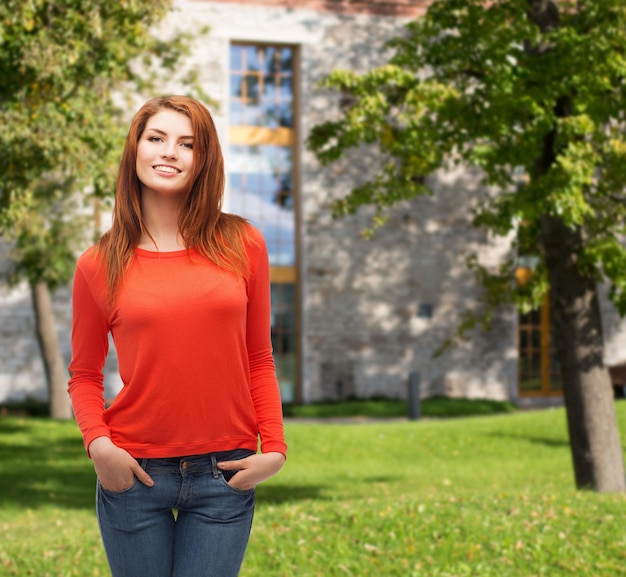 happiness and people concept - smiling teenager in casual top and jeans at campus