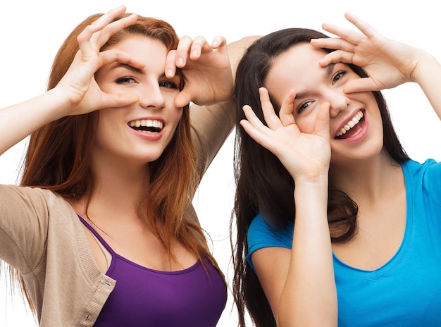 happiness and people concept - two young teenagers making funny faces