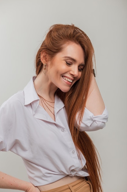 Happiness pretty redhead woman with white cute smile in fashion white shirt on a white background