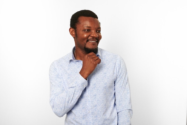 Happy african american black man in casual bright shirt brings hand to his small beard isolated