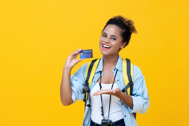 Happy African American female backpacker holding credit card 