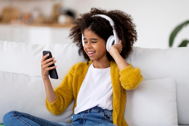 Happy african american preteen girl listening to music