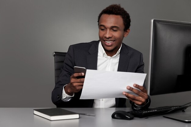 Happy African businessman with cellphone