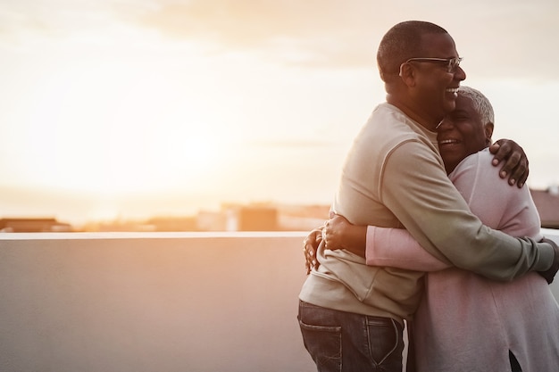 Happy african couple dancing outdoors at summer sunset - Focus on man face