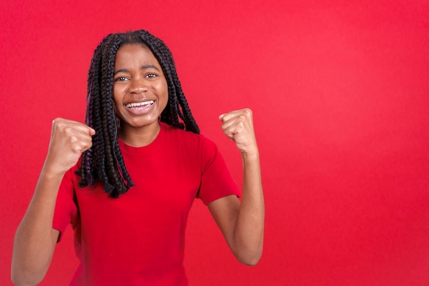 Happy african woman celebrating while raising arms