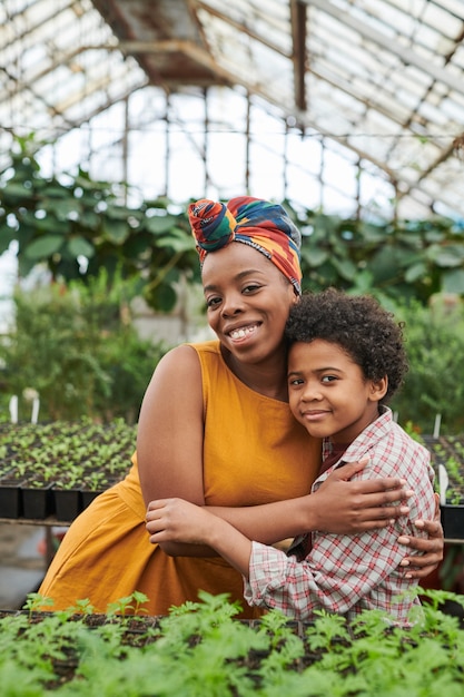 Happy African woman emracing her son while they working in the farm together