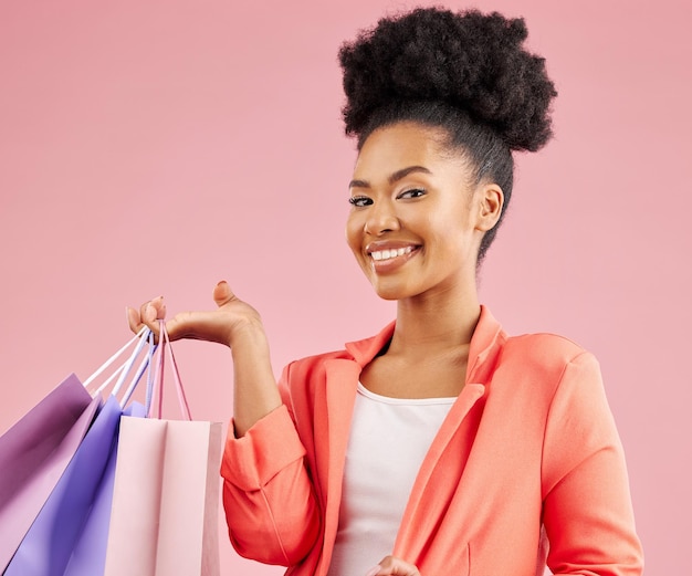 Happy African woman shopping bag and studio portrait for discount sale or smile by pink background Young gen z girl promotion and excited for deal retail customer experience or fashion for gift