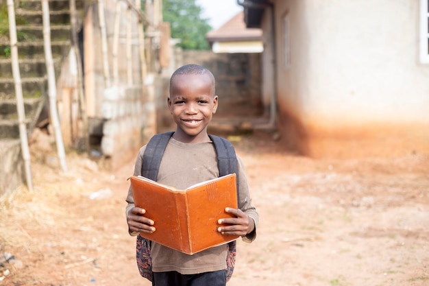 Happy afro American elementary male student entering school