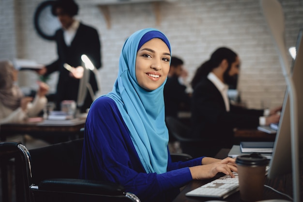 Happy Arab Lady in Wheelchair Works at Computer.