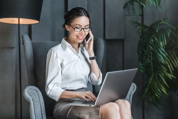 Happy asian business woman using notebook for work