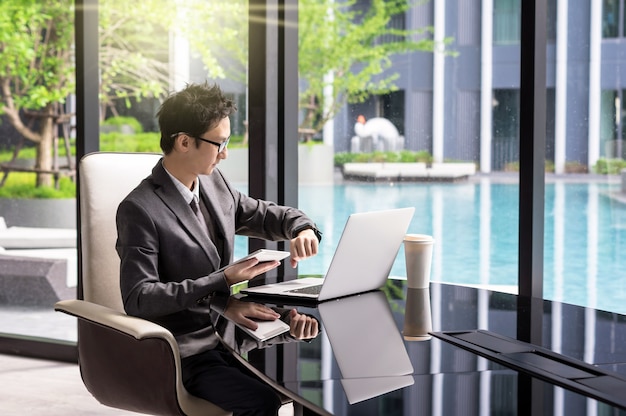 Happy asian businessman sitting on working space