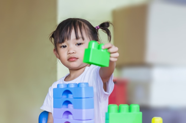 Happy Asian child girl playing the plastic block toys Learning and education