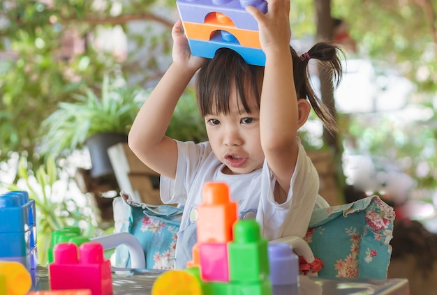 Happy Asian child girl playing the plastic block toys Learning and education