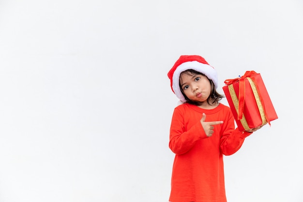 Happy Asian child in Santa red hat holding Christmas presents. Christmas time.on white background.