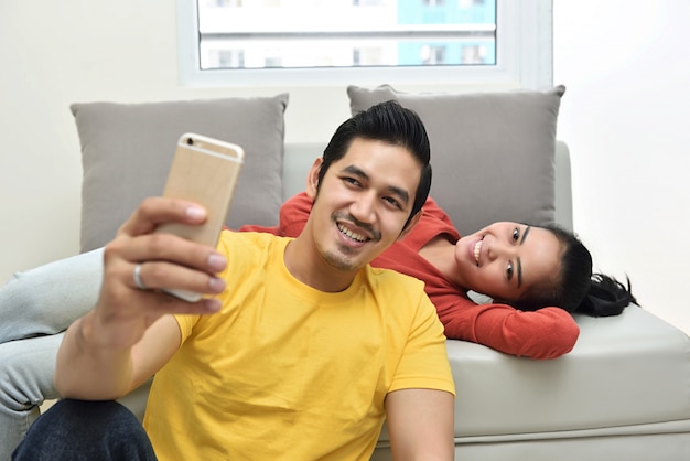 Happy asian couple having fun and taking a selfie