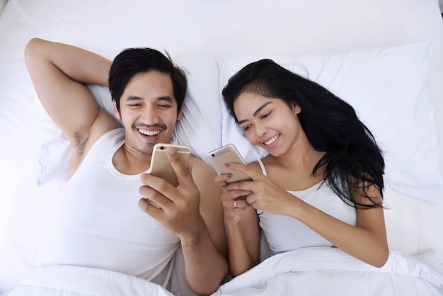 Happy asian couple with smartphones