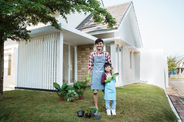 Happy asian daddy and son gardening at his house garden