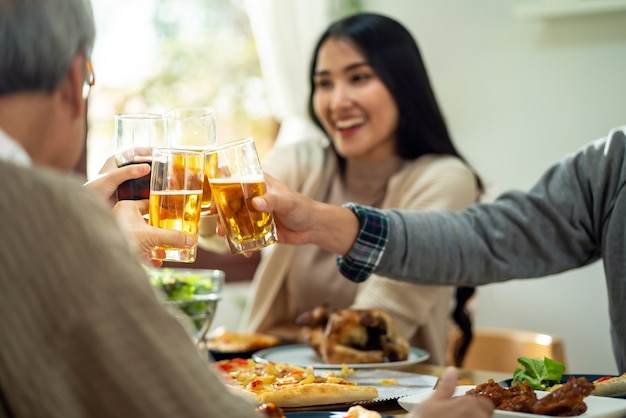 Happy Asian family cheers together during lunch