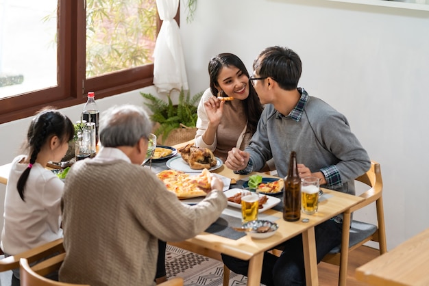 Happy Asian family eating lunch together at home