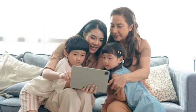 Happy Asian family using digital tablet in living at home relaxing at home for lifestyle concept