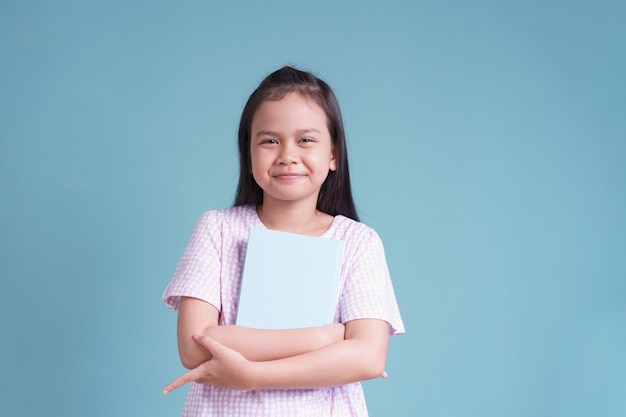 Happy Asian little girl standing holding the book