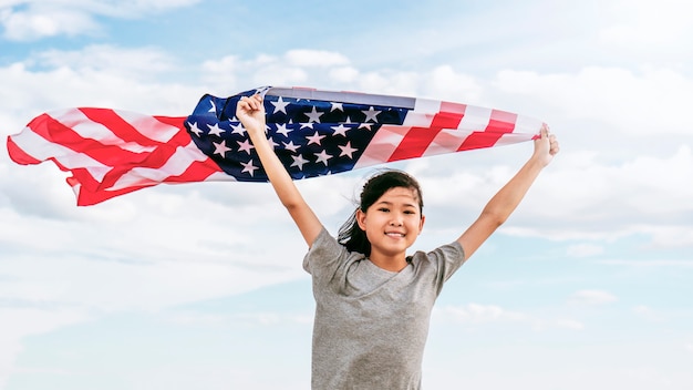 Happy asian little girl with American flag USA celebrate 4th of July