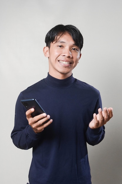 Happy Asian man using smartphone isolated on background