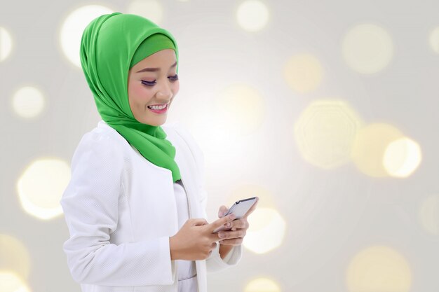 Happy asian muslim woman holding a phone 