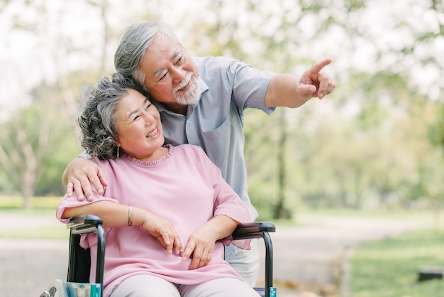 Happy Asian senior couple smiling outside